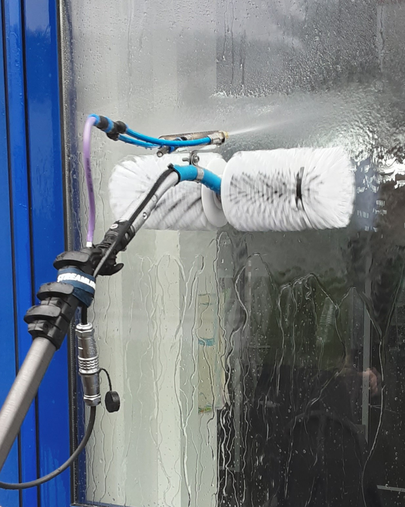 Rotierende Bürste Glasreinigung weisse, rotierende Bürste auf Fensterscheibe mit Wassersprüher
